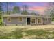 Charming one-story home with gray brick and vinyl siding, inviting front yard, and blossoming trees at 5323 Hilltop Cir, Charlotte, NC 28269