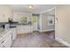 Well-lit kitchen with white cabinets, modern appliances, and durable laminate floors, seamlessly connects to other rooms at 5323 Hilltop Cir, Charlotte, NC 28269
