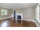 Bright living room with hardwood floors, a brick fireplace, and ample natural light from large windows at 5323 Hilltop Cir, Charlotte, NC 28269