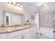 Bathroom boasts a granite countertop, white cabinetry, and tiled shower with a neutral color palette at 5419 Sunningdale Dr, Charlotte, NC 28277