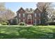Stately brick home with manicured lawn and mature landscaping exudes elegance at 5419 Sunningdale Dr, Charlotte, NC 28277