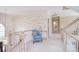 Upstairs hallway featuring a comfortable seating area, neutral carpet, and natural light at 5419 Sunningdale Dr, Charlotte, NC 28277
