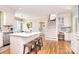 Well-lit kitchen featuring an island with seating, modern appliances, and hardwood floors at 5419 Sunningdale Dr, Charlotte, NC 28277