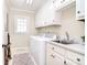 Well-lit laundry room with white cabinets, modern washer and dryer, and a sink at 5419 Sunningdale Dr, Charlotte, NC 28277
