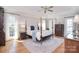 Spacious main bedroom featuring a four-poster bed, hardwood floors, and natural light from multiple windows at 5419 Sunningdale Dr, Charlotte, NC 28277