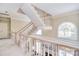 Elegant staircase with white railings and trim, accented by a large arched window at 5419 Sunningdale Dr, Charlotte, NC 28277