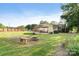 A relaxing backyard with lush green grass, a stone fire pit, a seating area, and a grill at 552 Odell School Rd, Concord, NC 28027