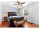 This bedroom features a dark wood bed frame, hardwood floors, a ceiling fan, and a window with lots of natural light at 552 Odell School Rd, Concord, NC 28027