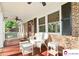 Cozy front porch with white wicker furniture and a ceiling fan for added comfort at 552 Odell School Rd, Concord, NC 28027
