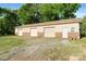 A large detached garage featuring 3 bays, a door, and a gravel parking pad in front at 552 Odell School Rd, Concord, NC 28027