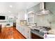 Modern kitchen features stainless steel appliances, light cabinetry, and lovely tile backsplash at 552 Odell School Rd, Concord, NC 28027