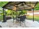 Charming outdoor seating area with a gazebo, ornate iron table and chairs and a small water feature at 552 Odell School Rd, Concord, NC 28027