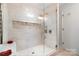 The shower features beige tiling and a glass door, equipped with multiple shower heads and a built-in niche at 552 Odell School Rd, Concord, NC 28027