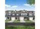 Charming townhome exterior featuring multiple garages, creating a delightful street view with manicured lawns at 6250 Tea Olive Dr # 240, Harrisburg, NC 28075