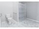 Bright bathroom featuring a toilet, shower with striped curtain, grey walls, and white-marbled floors at 6308 Brumit Ln, Charlotte, NC 28269