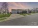 Charming single-Gathering home featuring a well-manicured lawn and attached two-car garage with extended driveway at 6308 Brumit Ln, Charlotte, NC 28269