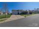 Inviting two-story home with an attached garage, solar panels, a front porch, and a well-manicured lawn at 6308 Brumit Ln, Charlotte, NC 28269