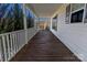 Inviting front porch with wood flooring, white railings, and views of the neighborhood at 6308 Brumit Ln, Charlotte, NC 28269