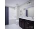 Well-lit bathroom featuring a bathtub-shower combination with a dark vanity and double sink at 7027 Short Stirrup Ln, Mint Hill, NC 28227