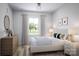 Comfortable bedroom with a wooden dresser, a large window and stylish decor at 7027 Short Stirrup Ln, Mint Hill, NC 28227