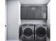 Efficient laundry room featuring gray cabinets and modern washer and dryer at 7027 Short Stirrup Ln, Mint Hill, NC 28227