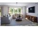 Bright living room with neutral furnishings, large windows, and a stylish striped rug at 7027 Short Stirrup Ln, Mint Hill, NC 28227