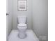 Clean, modern bathroom featuring a white toilet, matching white floors, and light grey walls at 7027 Short Stirrup Ln, Mint Hill, NC 28227