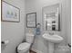 Charming powder room with pedestal sink, decorative mirror, and stylish accents at 7918 Nelson Rd, Mint Hill, NC 92227