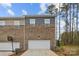 Exterior of a townhouse with a two-car garage and brick accents at 7918 Nelson Rd, Mint Hill, NC 92227