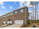 Townhome exterior with a white garage door and beautiful brick and neutral siding at 7918 Nelson Rd, Mint Hill, NC 92227