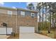 View of the townhome exterior with a white garage door and beautiful brick and siding at 7918 Nelson Rd, Mint Hill, NC 92227