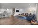 Open-concept living room with hardwood floors, a statement wall, and comfortable seating at 7918 Nelson Rd, Mint Hill, NC 92227