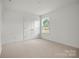 Bright bedroom featuring a window and double door closet at 9516 Coast Laurel Nw Ave, Concord, NC 28027