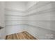 Walk-in pantry with white wire shelving and hardwood floors for optimal kitchen organization at 9516 Coast Laurel Nw Ave, Concord, NC 28027