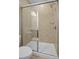 Tiled shower with a glass door, a shower head, and neutral colored tile at 9516 Coast Laurel Nw Ave, Concord, NC 28027