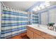 Bright bathroom with blue walls, a shower with curtain, wooden cabinets, and hardwood floors at 9709 Emerald Point Dr # 6, Charlotte, NC 28278