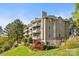 Exterior view of a lakeside condo with green grass, trees and balcony at 9709 Emerald Point Dr # 6, Charlotte, NC 28278