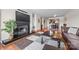 Comfortable living room with a fireplace, TV, hardwood floors, and area rug leading to the dining area at 9709 Emerald Point Dr # 6, Charlotte, NC 28278