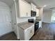 Well-lit kitchen with white cabinets, granite countertops, and stainless steel appliances at 1054 Horizon Ln, Chester, SC 29706
