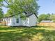 Backyard view of renovated home, featuring manicured lawn and new wooden fence at 108 Graham St, Chester, SC 29706