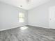 An empty bedroom has one window, wood look floors and neutral paint at 108 Graham St, Chester, SC 29706
