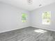 Empty bedroom with two windows showing trees outside, neutral paint and wood look floors at 108 Graham St, Chester, SC 29706