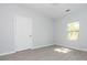 An empty bedroom with a new door and window; neutral gray walls and wood look floors at 108 Graham St, Chester, SC 29706