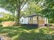A cozy front porch is surrounded by mature trees and a wooden fence at 108 Graham St, Chester, SC 29706