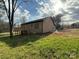Back exterior featuring a brick home with a deck and sunny backyard, perfect for outdoor living at 1112 Sedgewood Ln, Lincolnton, NC 28092