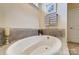 Close up of soaking tub with neutral tile surround at 11144 Limehurst Pl, Charlotte, NC 28278