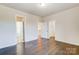Spacious bedroom with hardwood floors, multiple doorways, and natural light, offering a versatile layout at 11144 Limehurst Pl, Charlotte, NC 28278