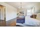 This primary bedroom boasts natural light, stylish furniture and hardwood floors at 11144 Limehurst Pl, Charlotte, NC 28278