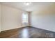 This bright bedroom features a window with natural light and hardwood floors at 11144 Limehurst Pl, Charlotte, NC 28278