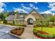 Beautiful stone clubhouse entrance with manicured landscaping and accessible parking on a partly cloudy day at 11144 Limehurst Pl, Charlotte, NC 28278